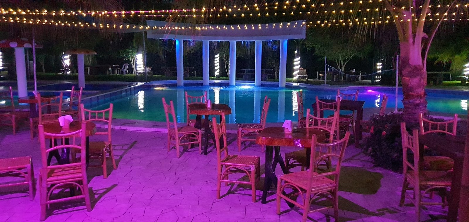 Evento nocturno junto a la alberca con iluminación